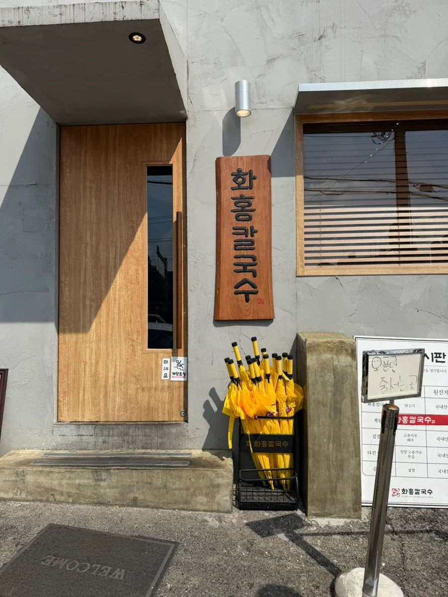 木の縦看板が掛かる入口