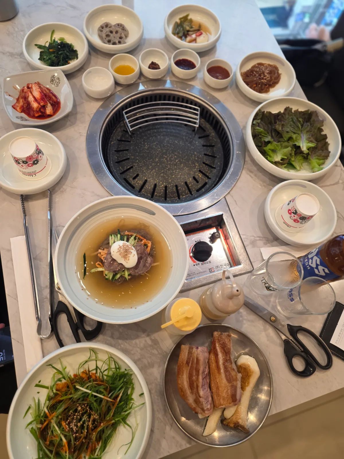黄金牧場 明洞店 — 焼肉とおかずが並ぶ食卓