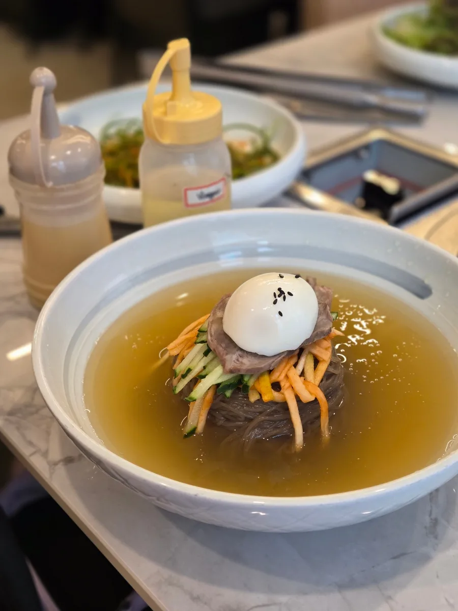 ゆで卵と錦糸状の野菜をのせた水冷麺