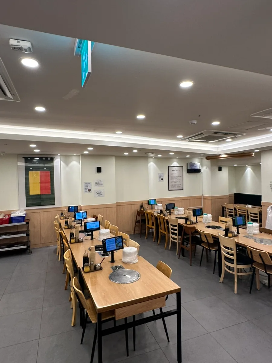 ヒョダム・カルグクス・タッカンマリ 明洞本店 — 注文端末のある木のテーブル席