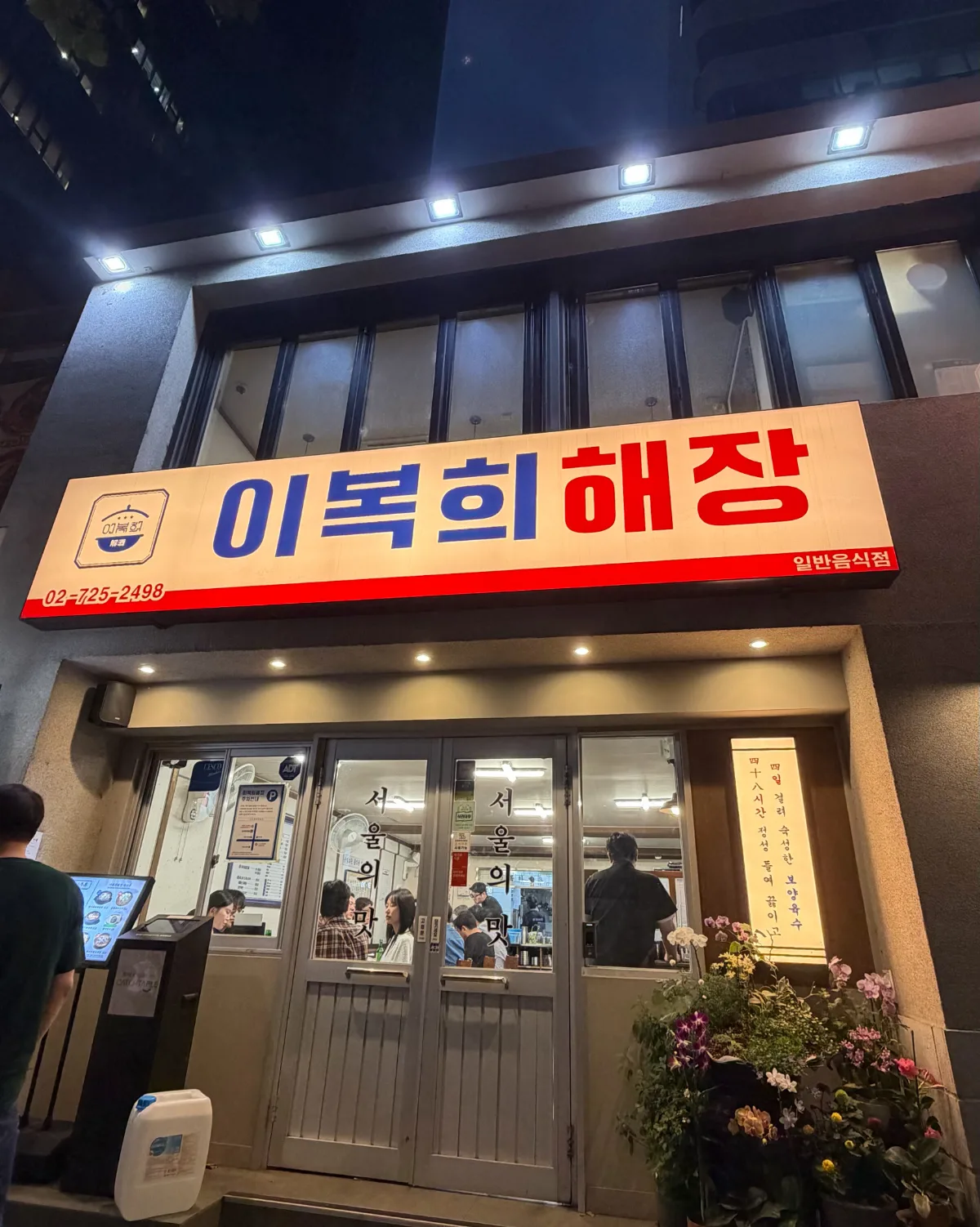 赤と白の看板が目立つ夜の店先