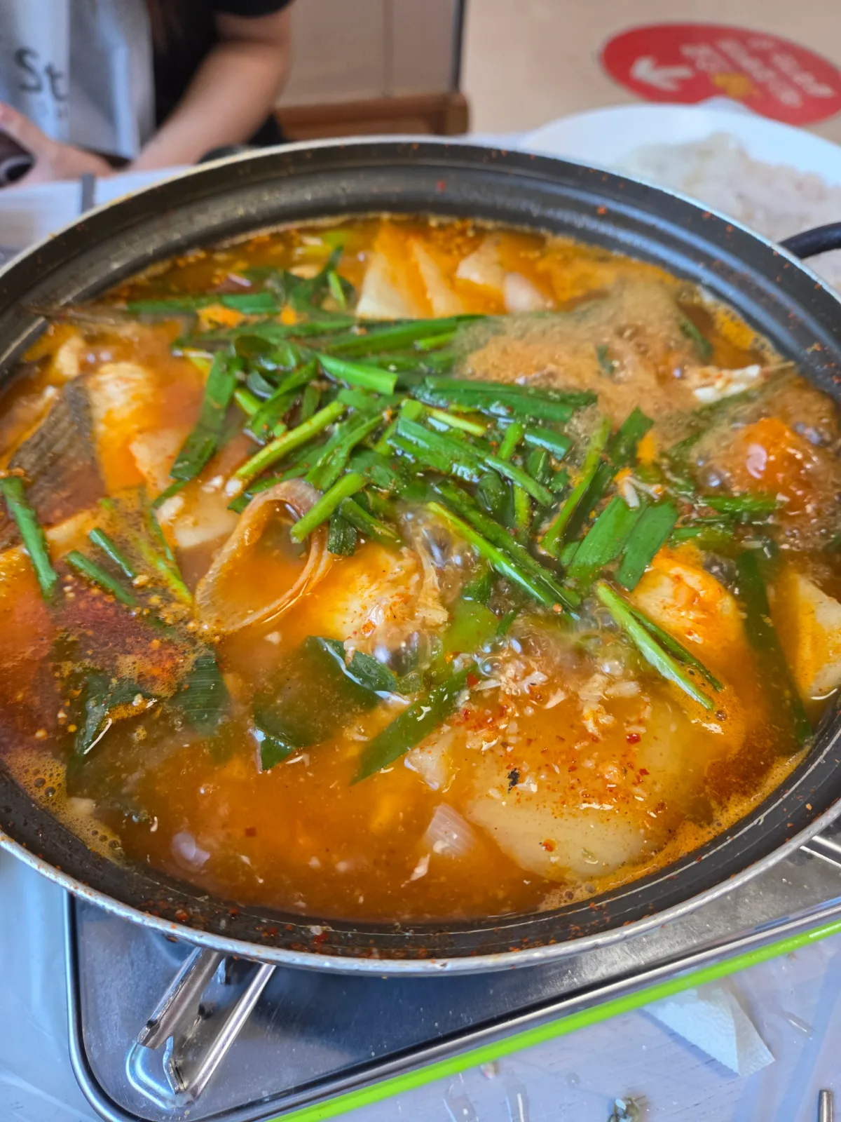 唐辛子の赤いスープで煮える魚とニラの鍋