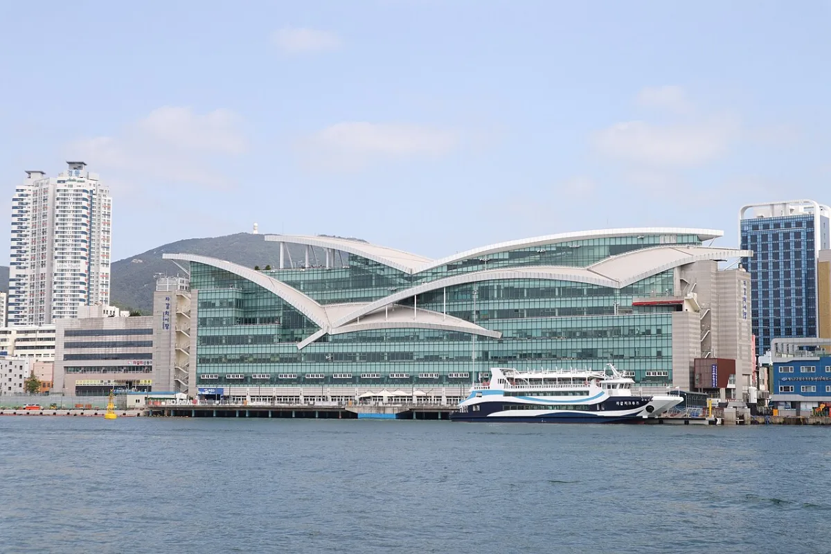 海から見たチャガルチ市場の建物。カモメが翼を広げたような屋根と停泊する船