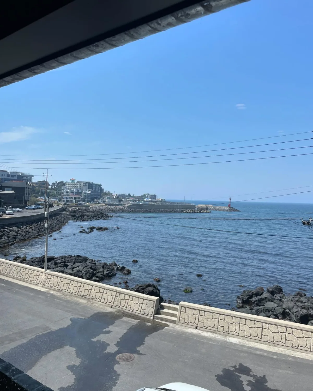 窓越しに見える海岸道路と青い海