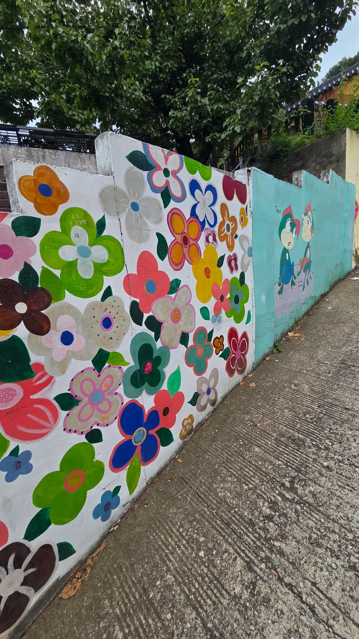 滋満壁画村 — 坂道の塀を彩る花の壁画