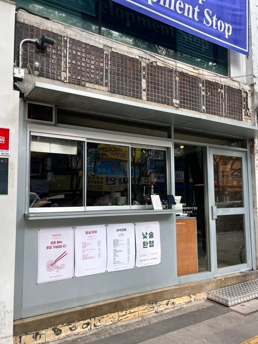 看板のない外観と、窓に貼られたメニュー