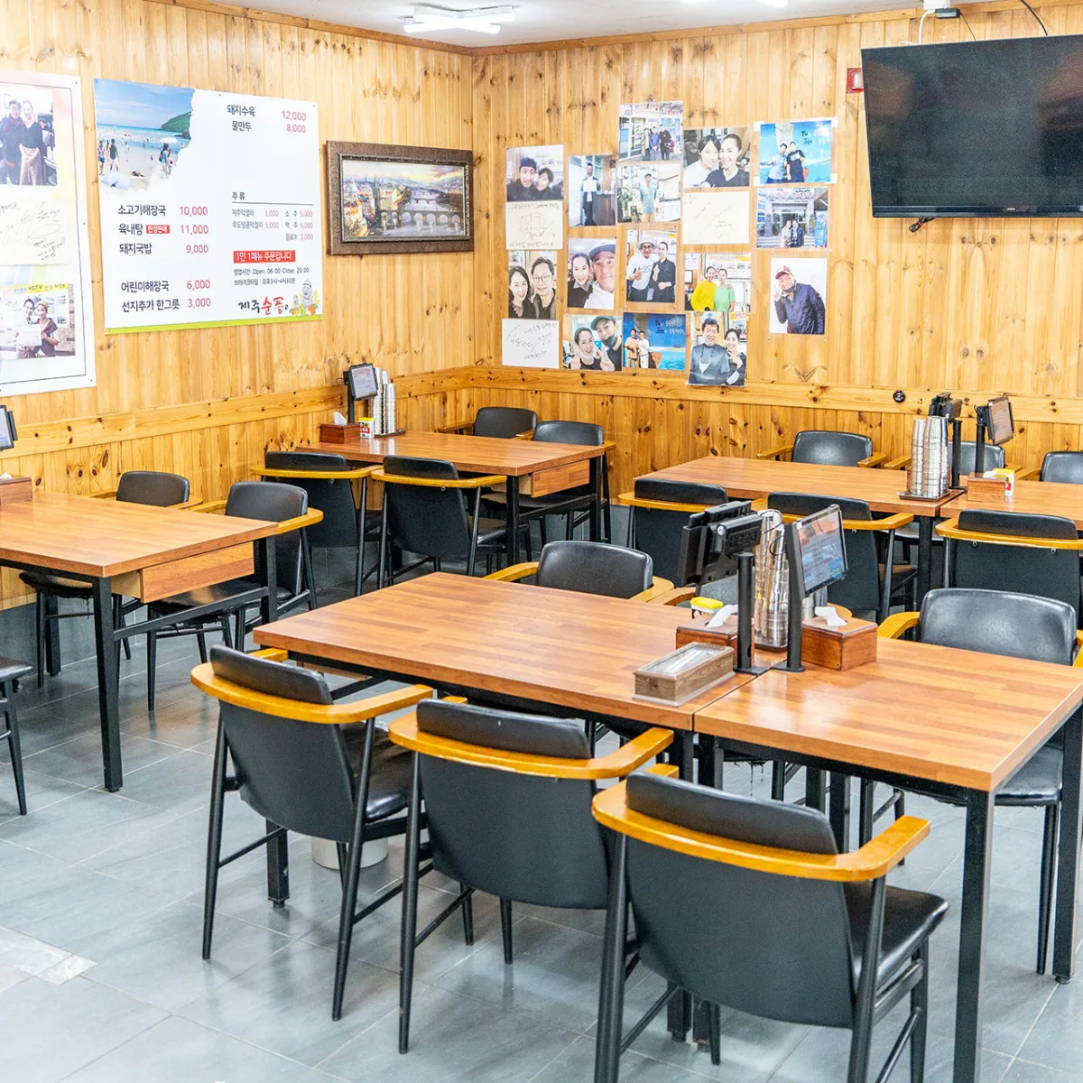 スンプンヘジャングク 咸徳店 — 木の壁とテーブル席が並ぶ店内