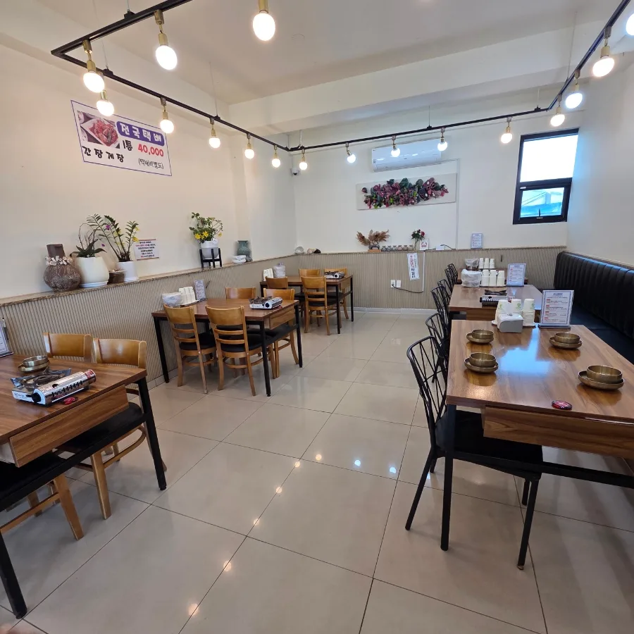 チェジュロウン・チョンヘウォン 城山日出峰店 — 木のテーブルと椅子が並ぶ店内
