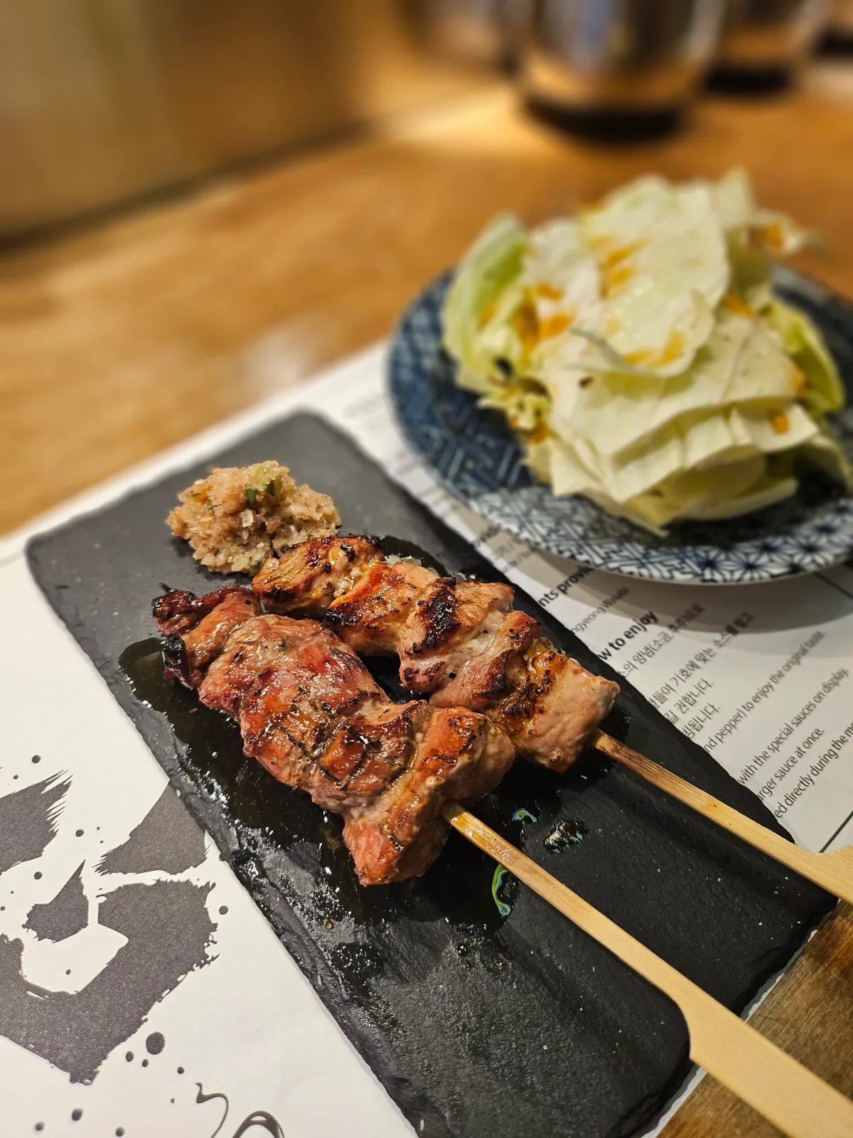 チョクシム — 黒い皿にのった豚肉の串焼き