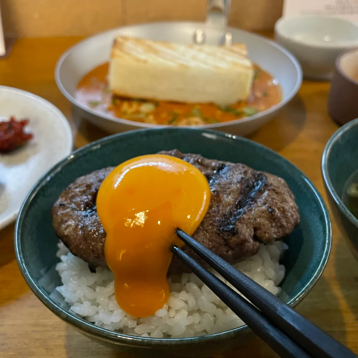 ハンバーグとご飯にとろりと流れる卵黄