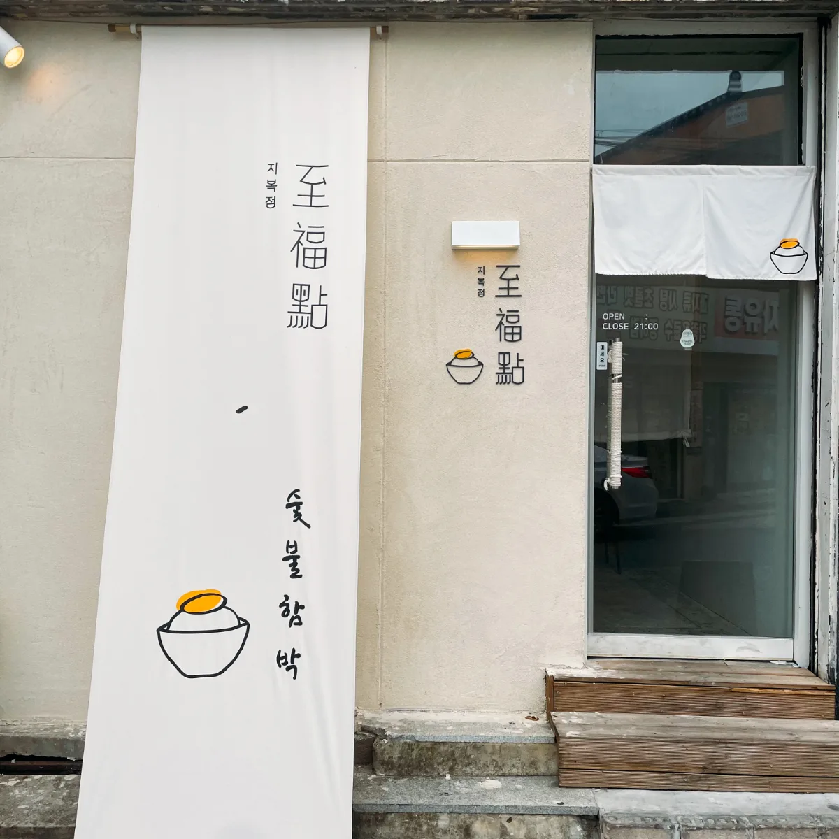 「至福點」の看板と白い垂れ幕がかかる店の入口