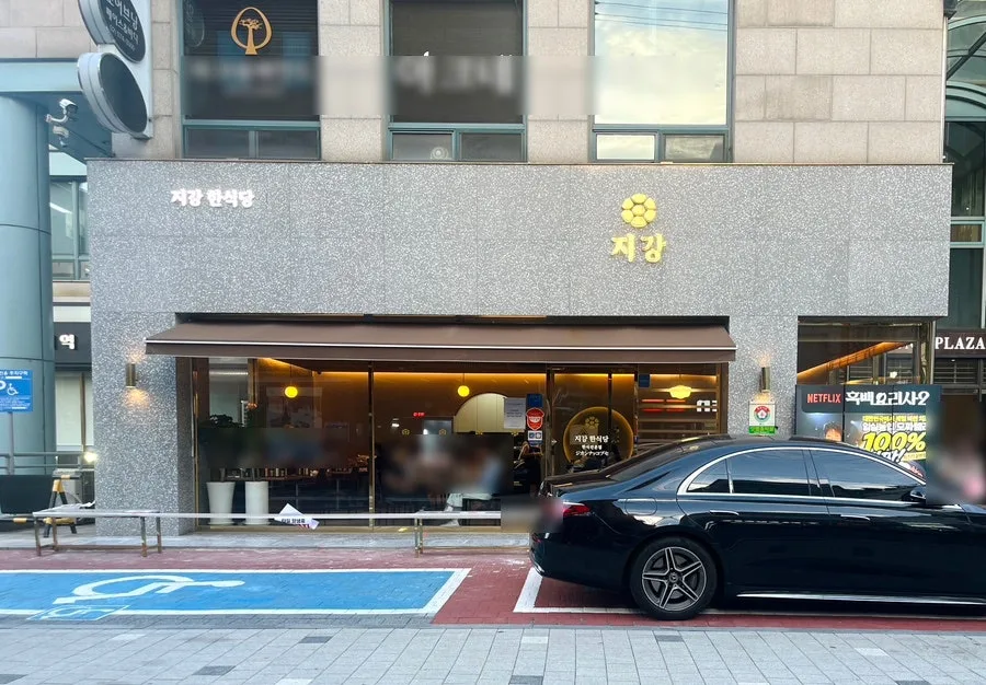 ジガンハン食堂 狎鴎亭本店 — 店名が光る石張りの外観