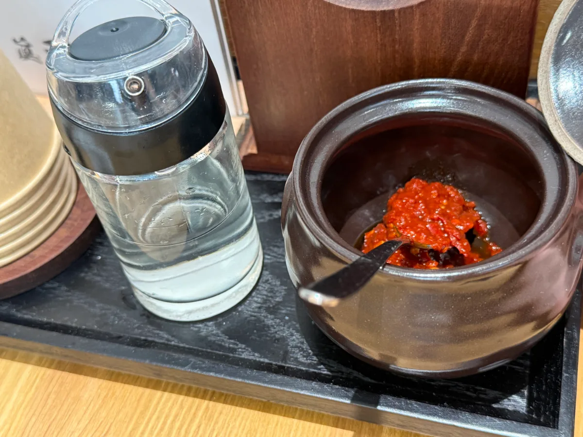 卓上の赤い調味料と透明な液体