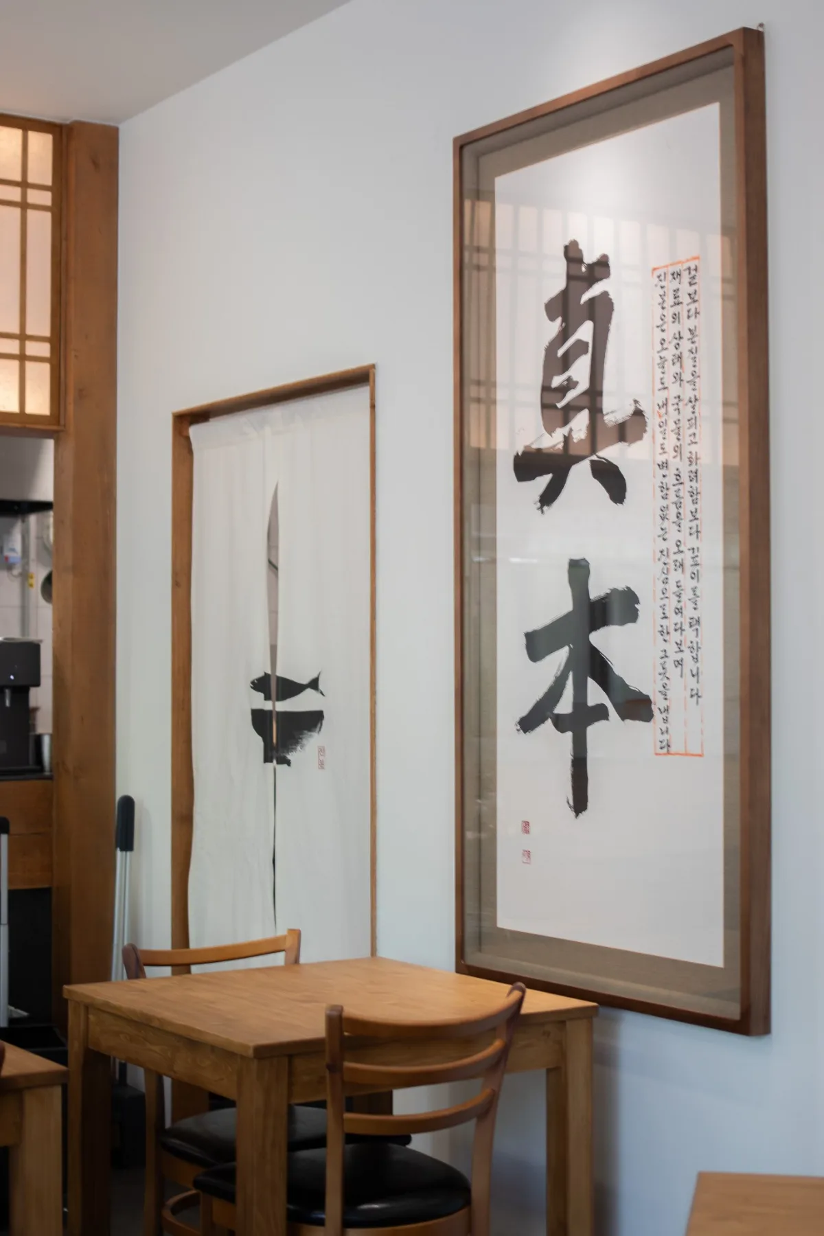 「真本」の書と木のテーブル