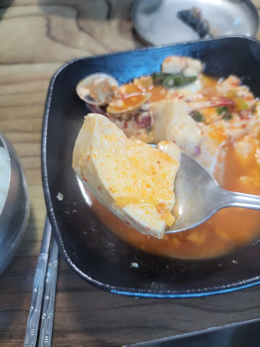 赤いチゲの豆腐をすくうスプーン