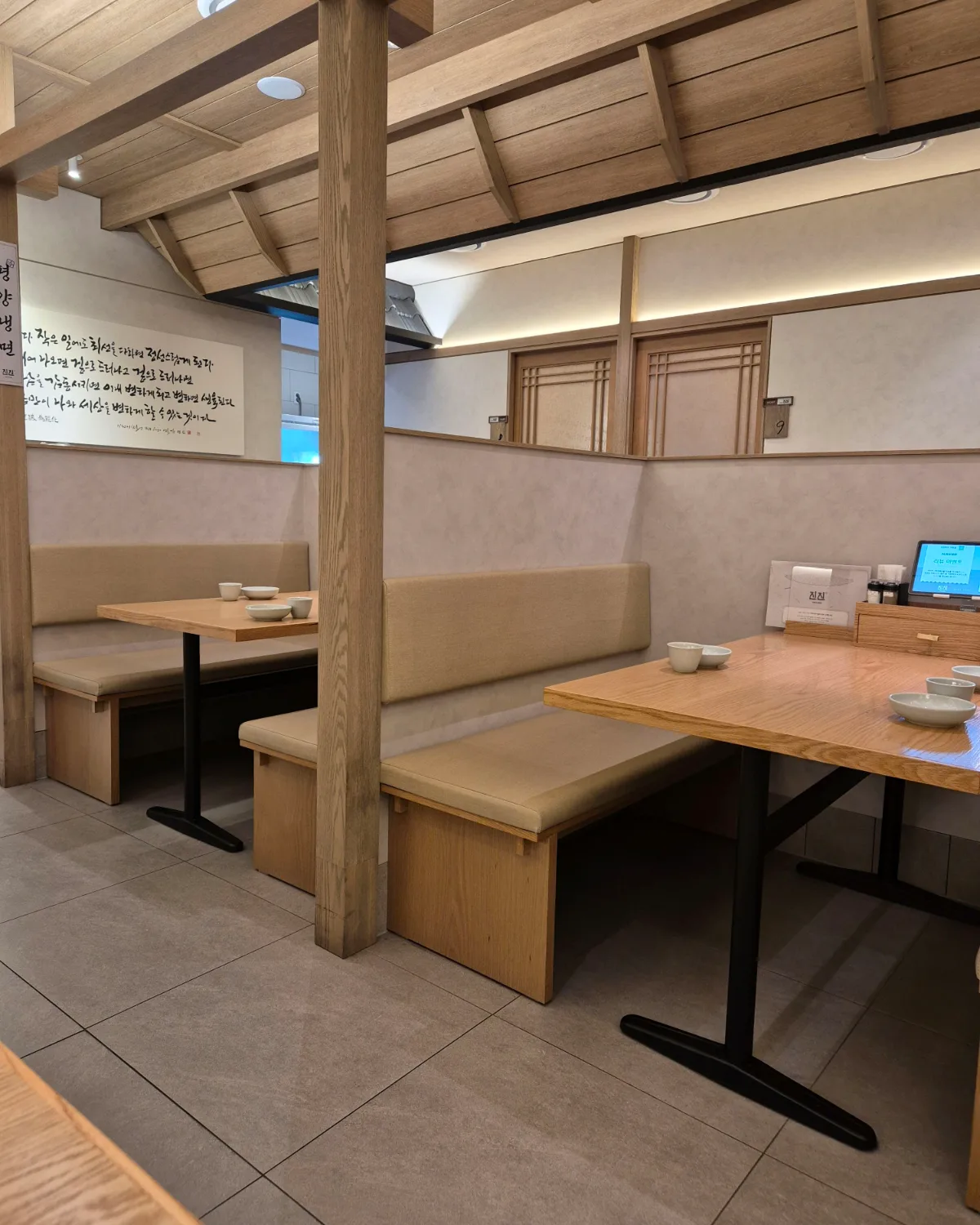 JINJIN MANDU 市庁店 — 木の柱に囲まれたベンチ席