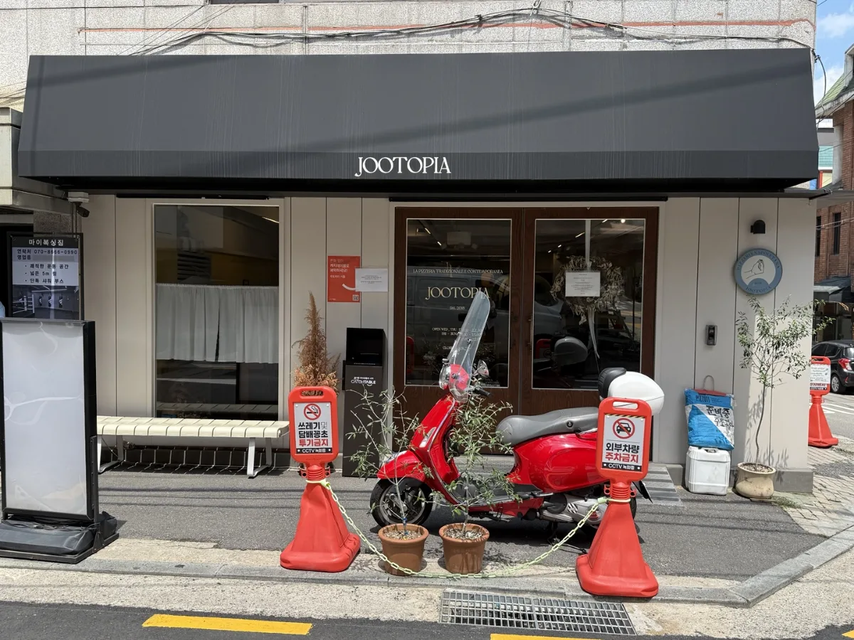 JOOTOPIA ソウル店 — 黒いひさしと木製扉の店先