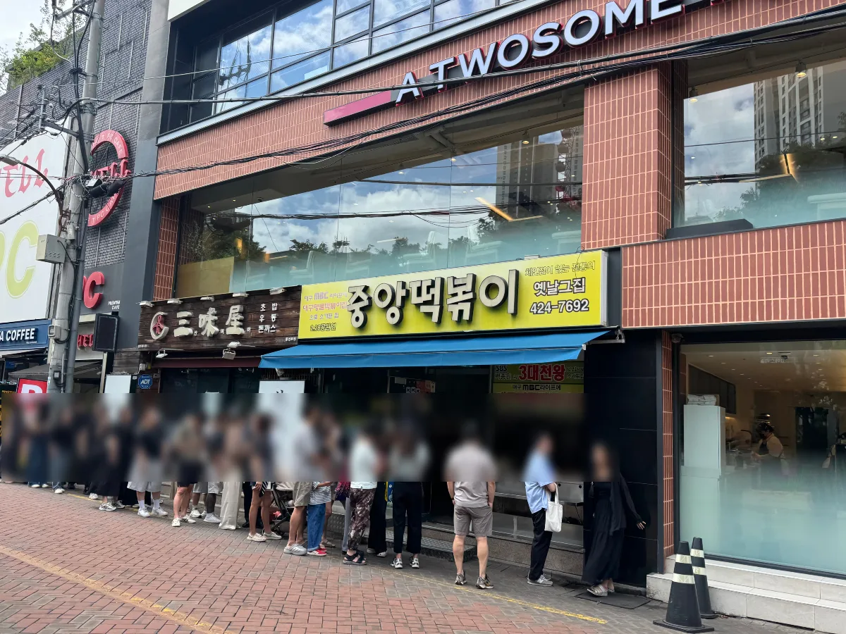 黄色い看板の店先に延びる行列