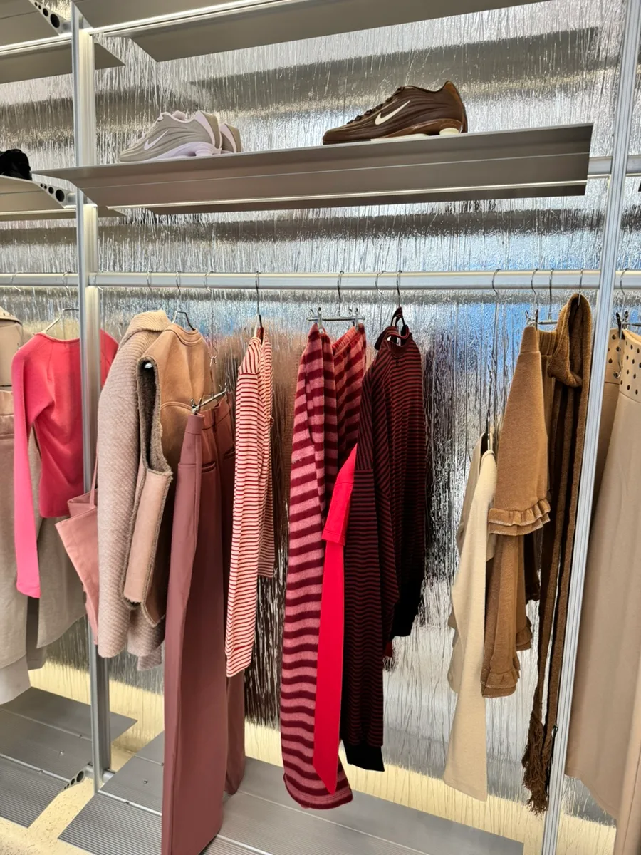 カシナ 聖水店 — ピンクの服と棚に並ぶスニーカー