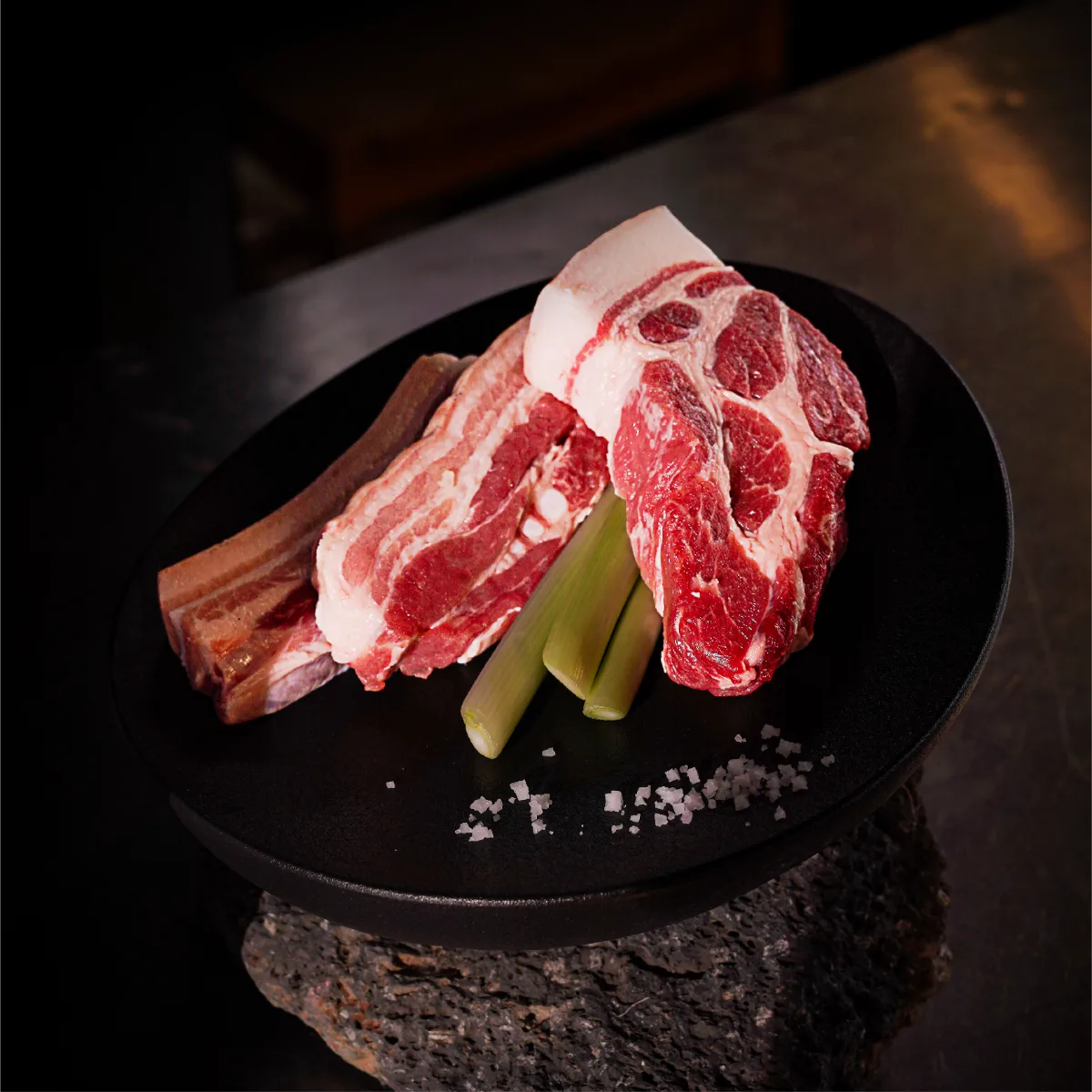 クンドンガ 中文店 — 黒い皿に盛られた生の豚肉