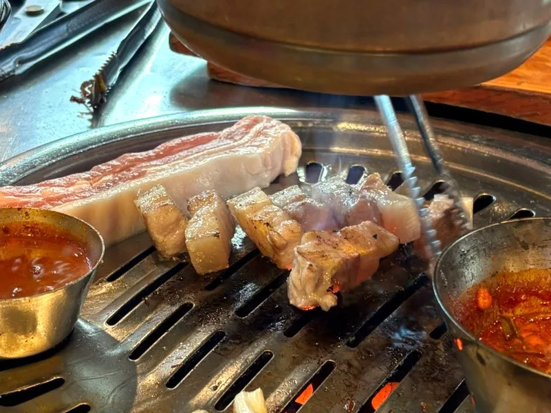 練炭の火の上で焼かれる厚切りの豚肉