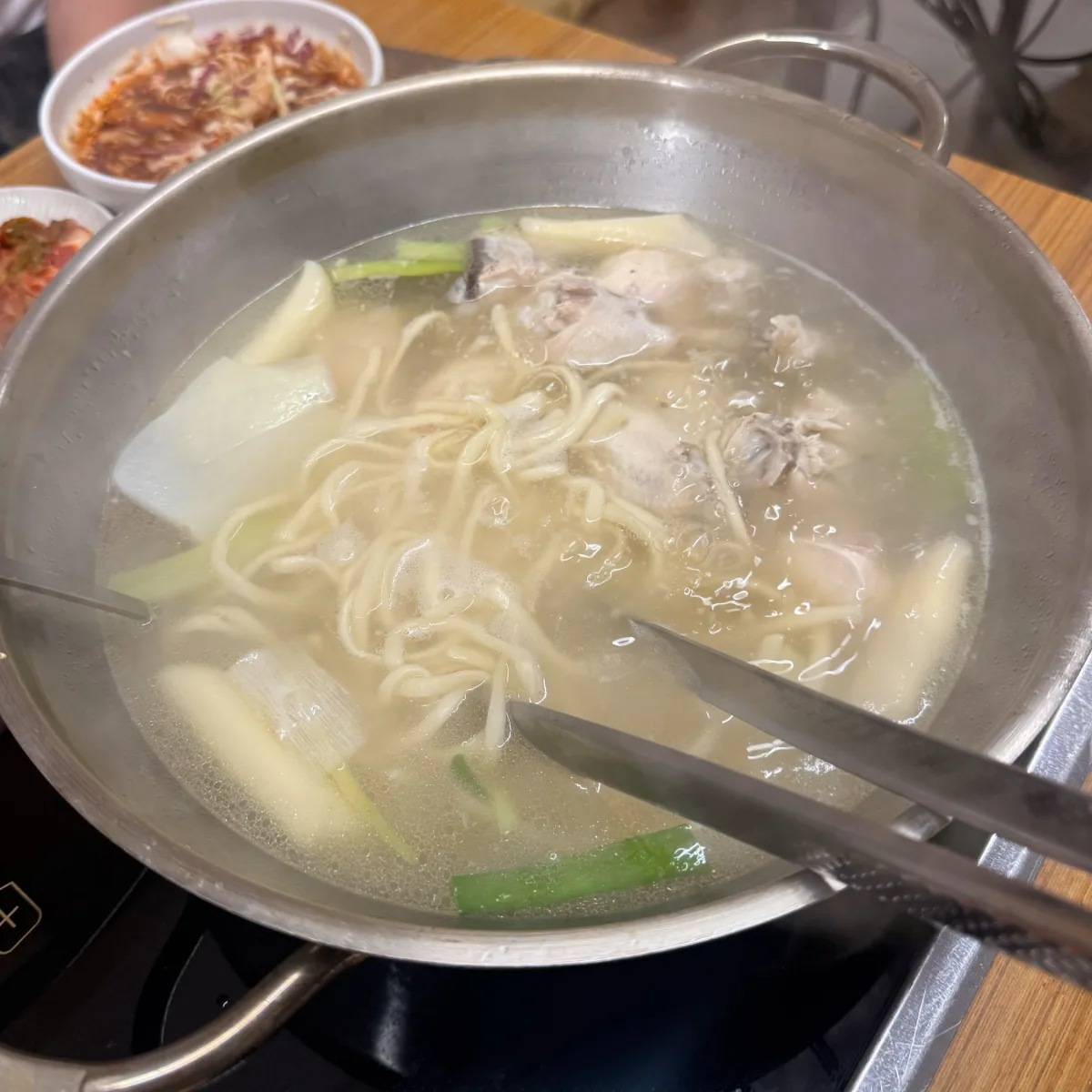 鶏肉と麺を煮込む大鍋