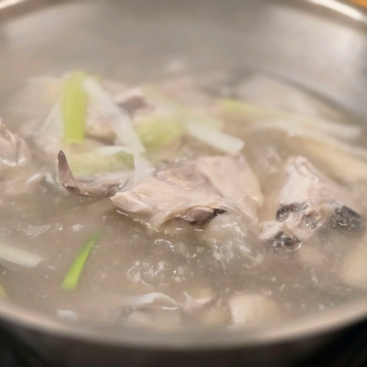湯気の立つスープと骨付き鶏肉
