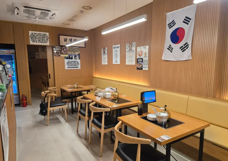 キムシネ・タッカンマリ 明洞本店 — 木目の壁と鍋用のテーブル席
