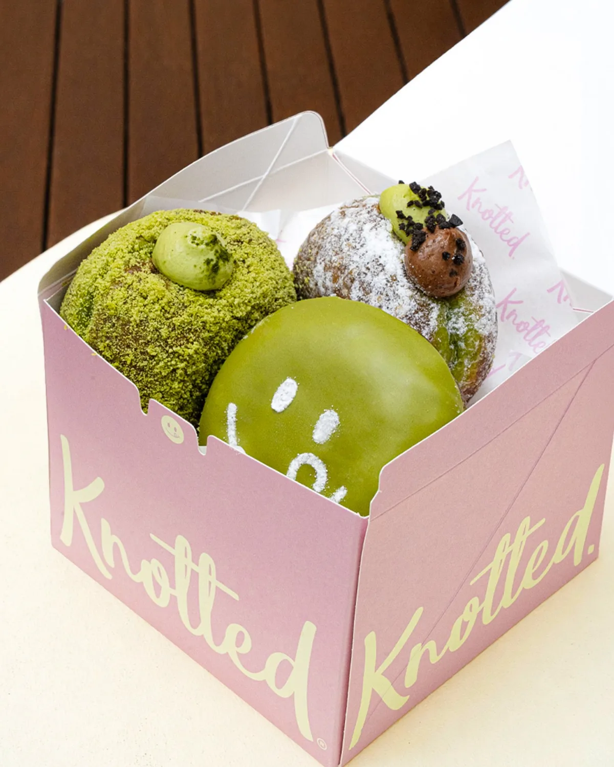 Knotted 済州DT店 — ピンクの箱に並ぶ緑のドーナツ
