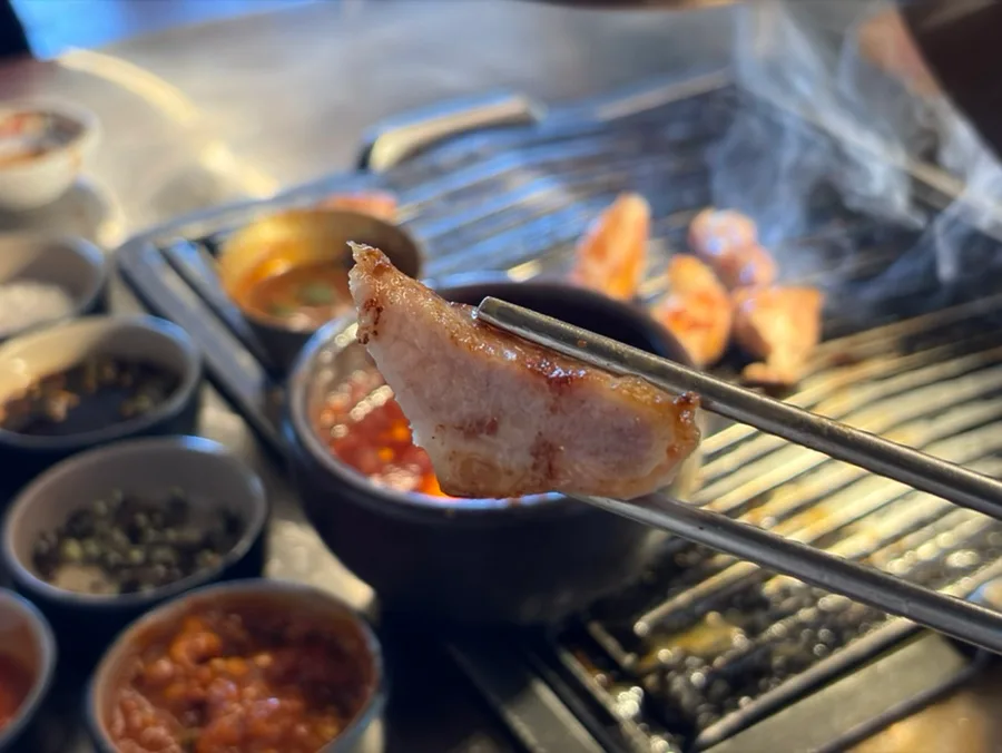 KOGIJANG 本店 — 箸で持ち上げた焼き豚肉