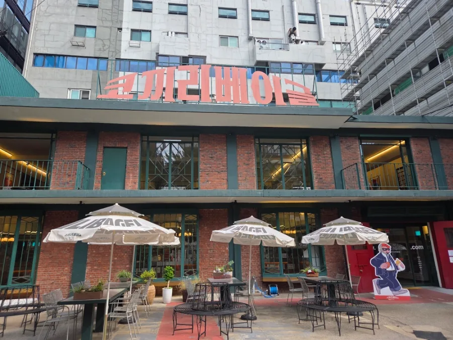 コッキリベーグル 聖水店 — 赤い看板とレンガ造りの店先