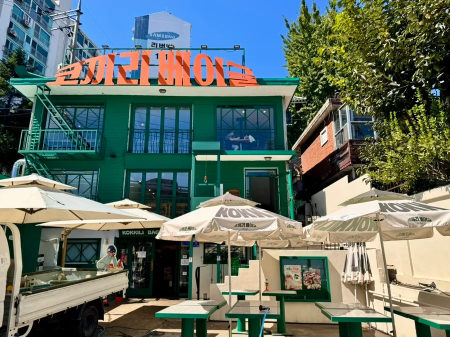 緑の建物と屋外のパラソル席