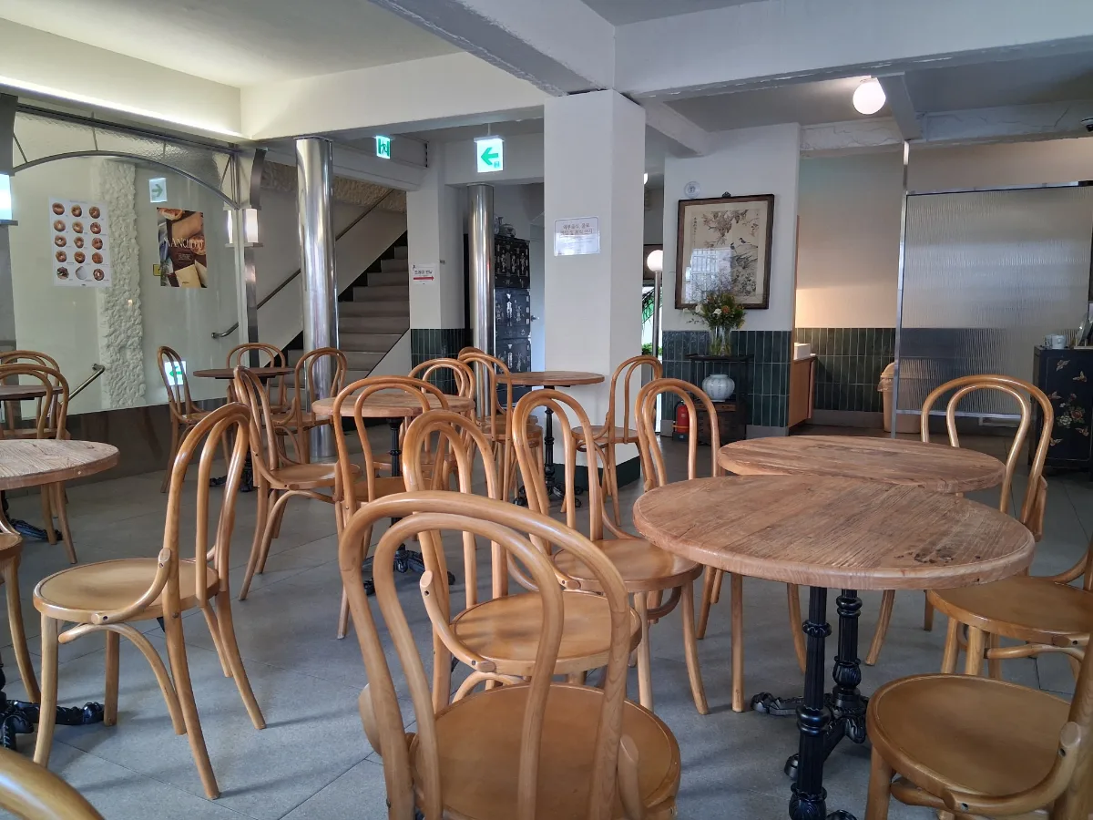 コッキリベーグル 仁寺洞店 — 木の椅子と丸テーブルが並ぶ店内
