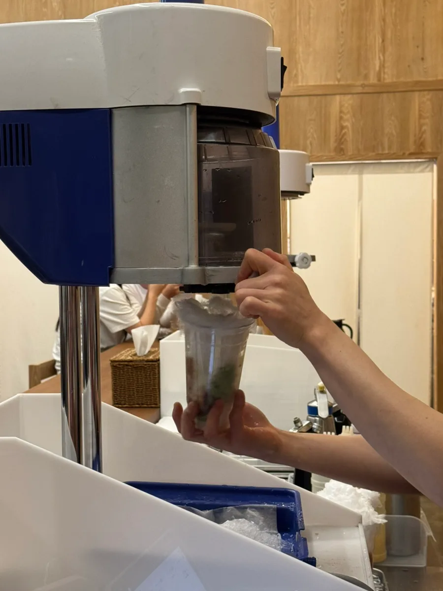 機械で氷を削ってカップに重ねる様子