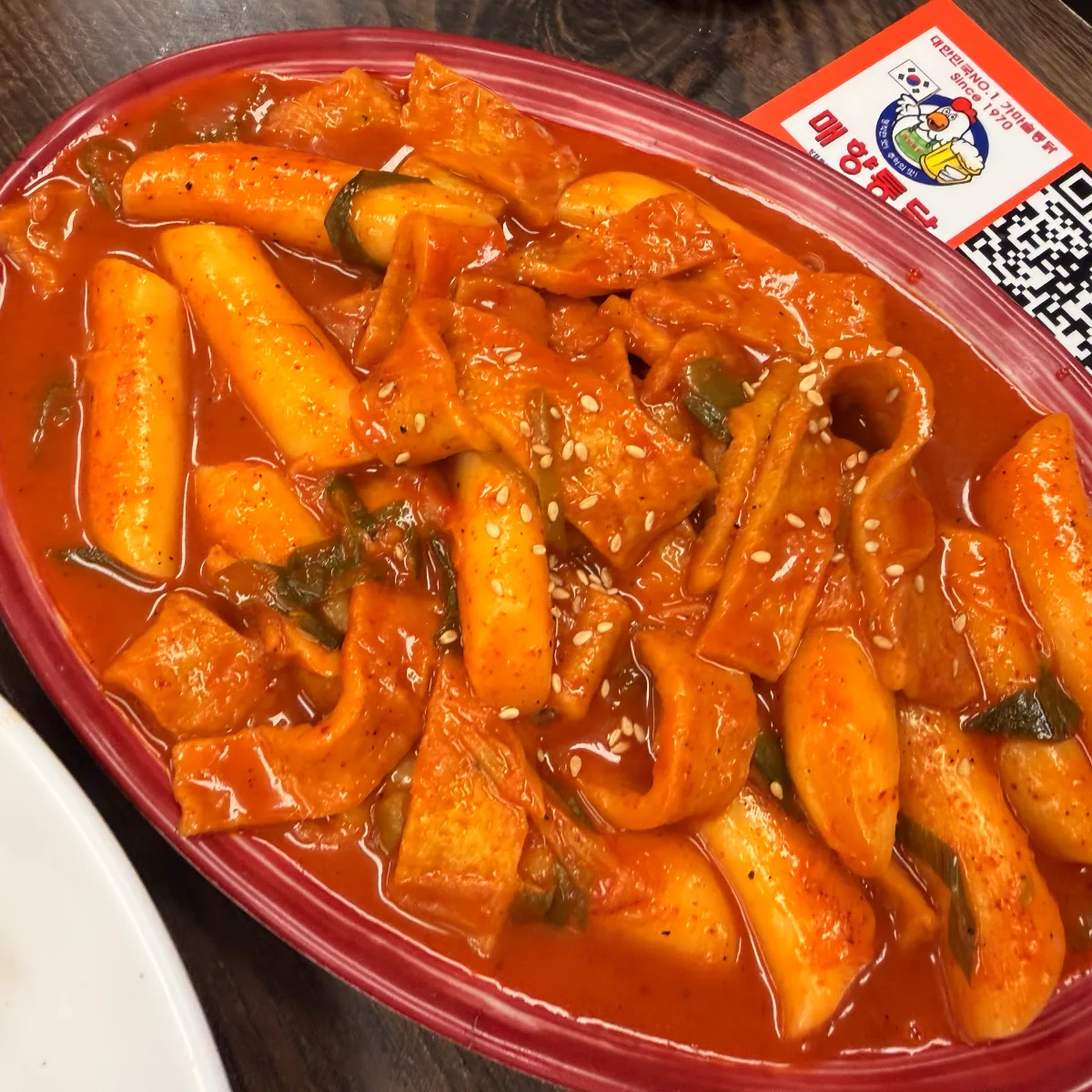 赤いたれに絡む餅と練り物