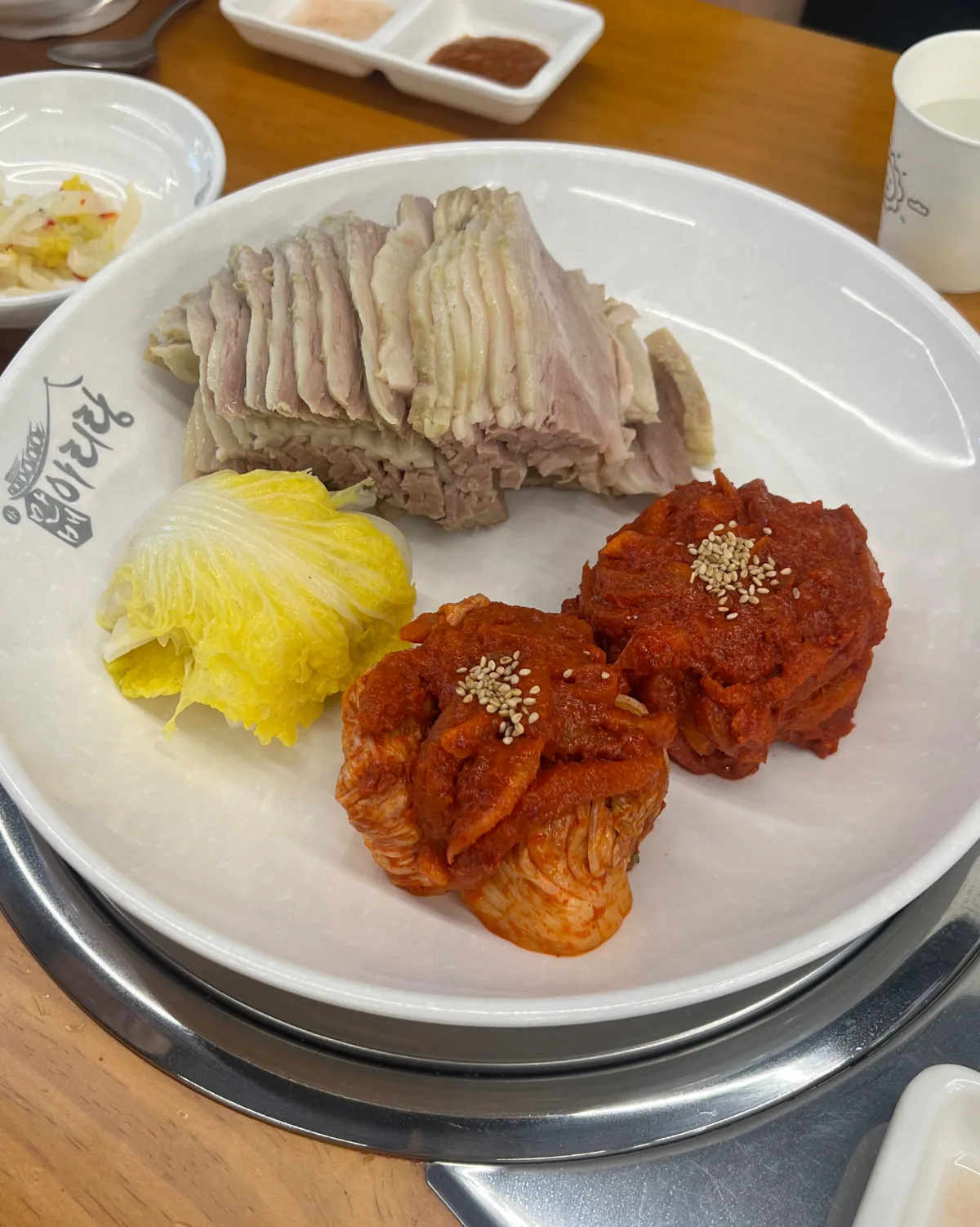 マンベアリランポッサム 乙支路店 — 白菜とキムチの具を添えたポッサムの皿