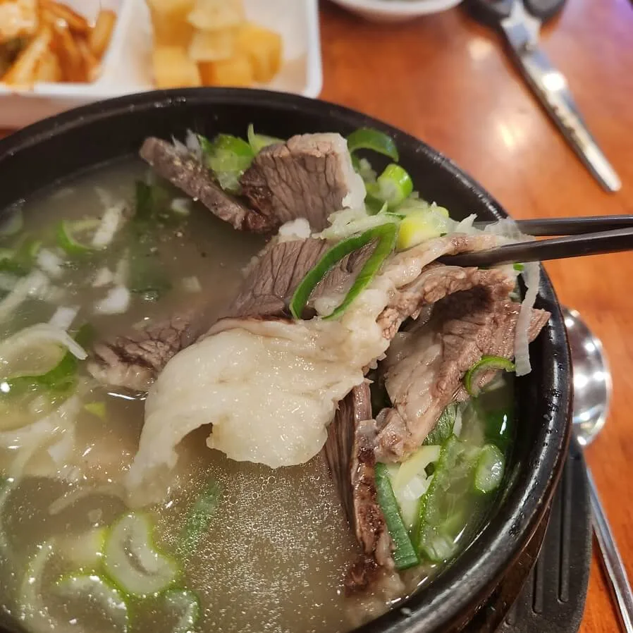 箸で持ち上げた脂身のある牛肉