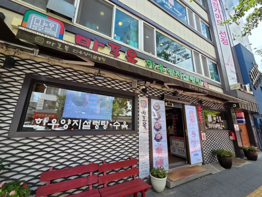 麻浦屋 — 麻浦屋の看板と入口の赤いベンチ