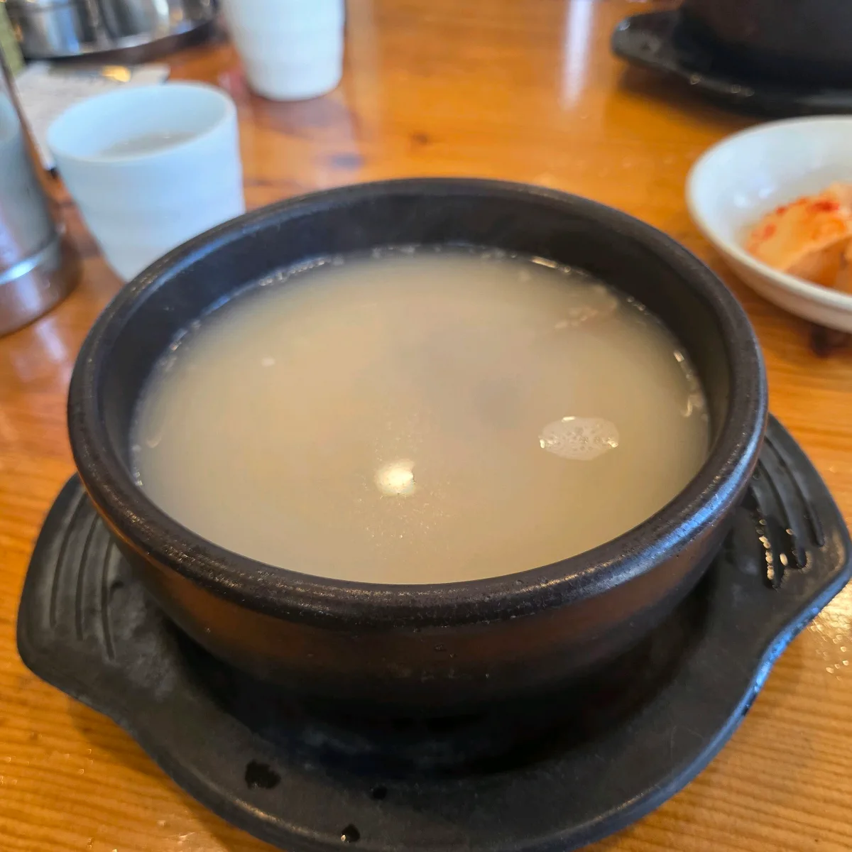 黒い器に盛られた白濁スープ
