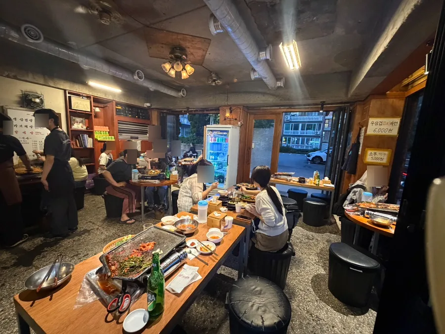 マッキムチ生サムギョプサル 延南店 — 木のテーブルが並ぶ店内