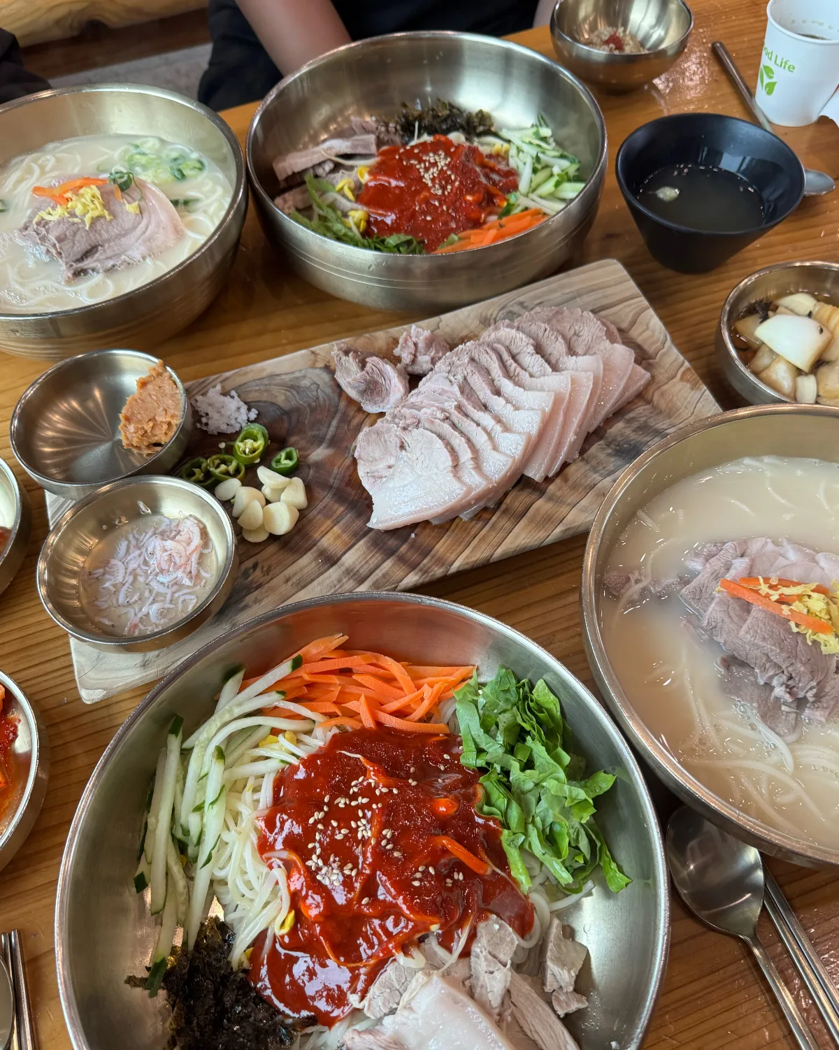 モクドルコギグクス 済州本店 — 麺料理とゆで豚が並ぶ食卓