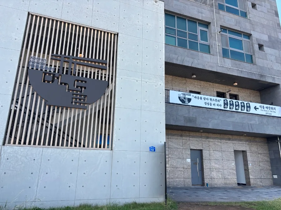 モクドルコギグクス 済州本店 — 麺どんぶりのロゴがある建物の外観