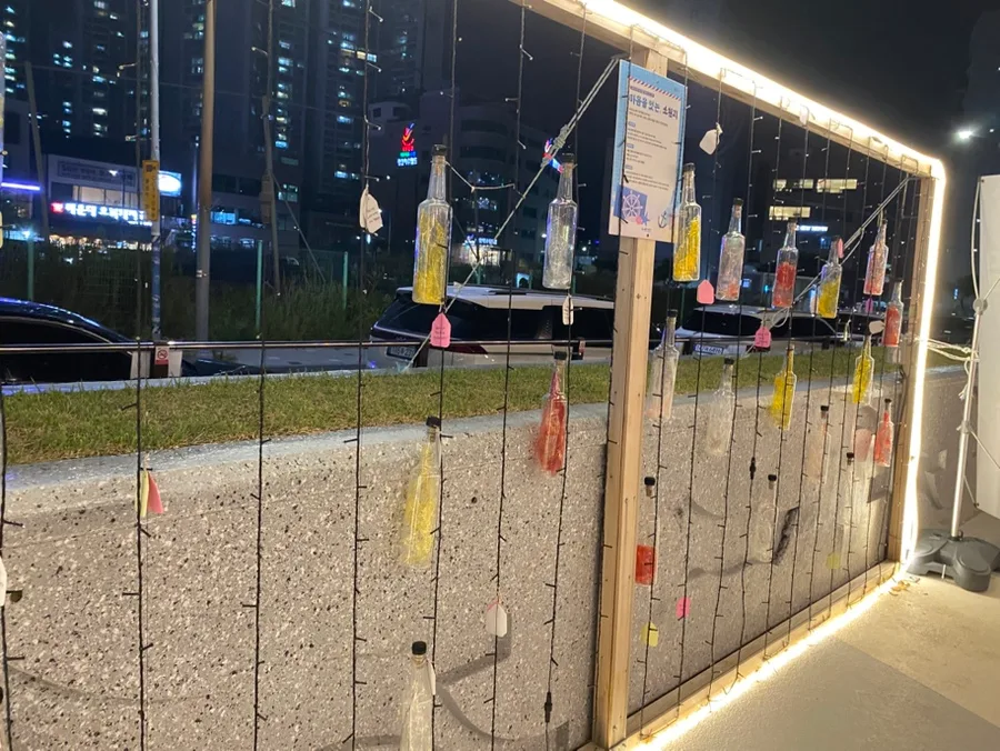 民楽水辺公園 — 光の枠に吊るされた色付きの瓶