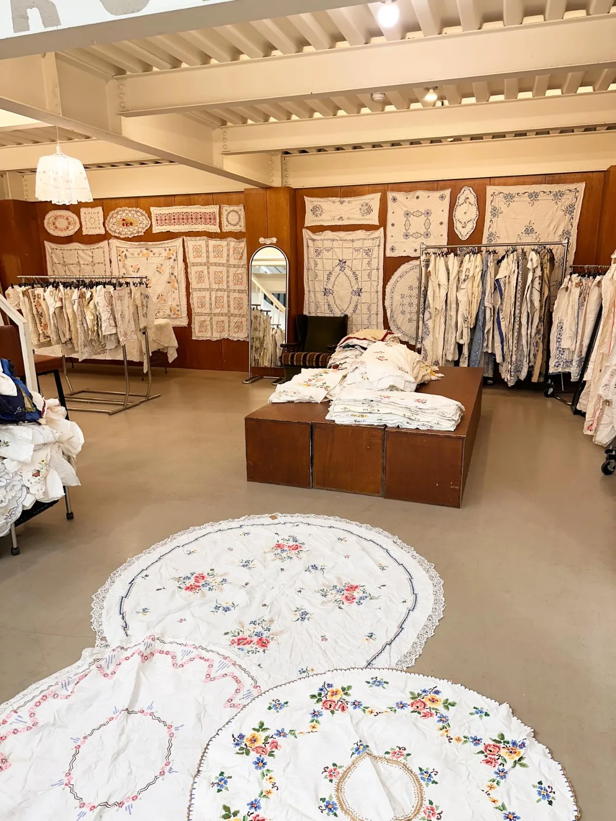 ミリオンアーカイブ — 刺繍布を壁や台に広げた売り場