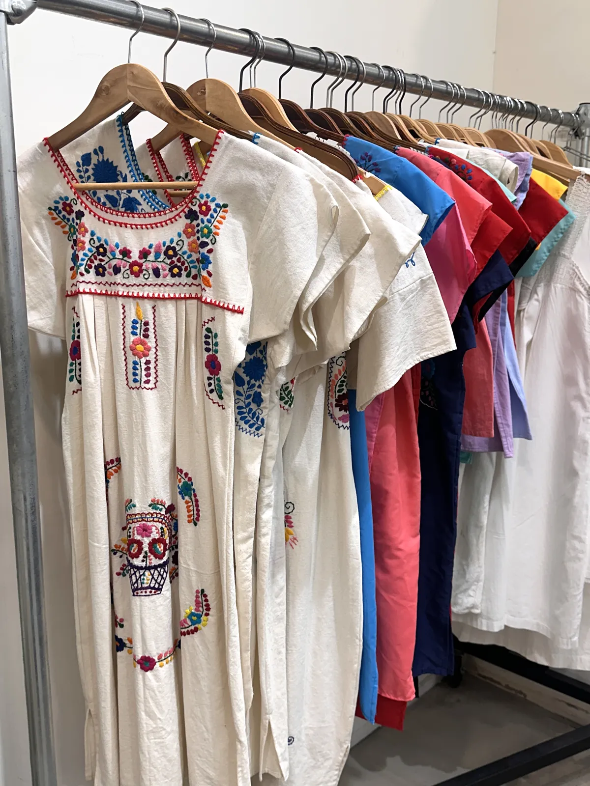 刺繍入りの白いワンピースなどが並ぶラック