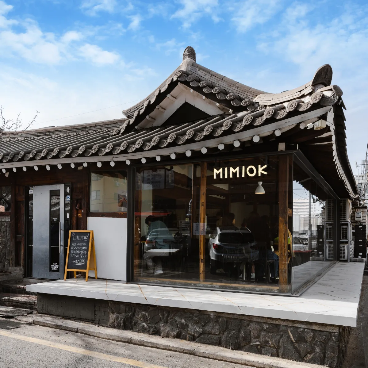 美米屋 新龍山店 — 瓦屋根とガラス張りの店舗