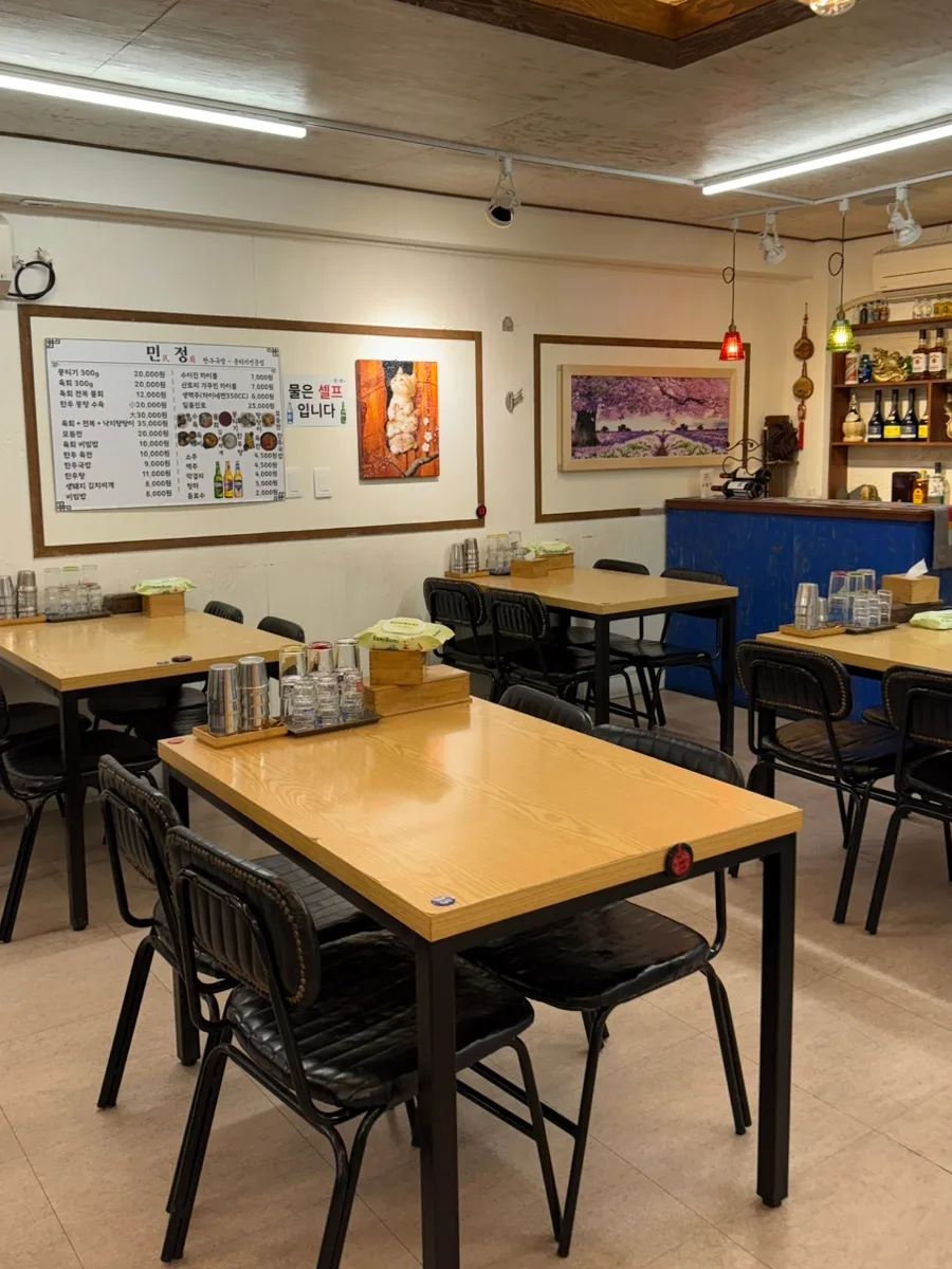 木目のテーブルと黒い椅子が並ぶ店内