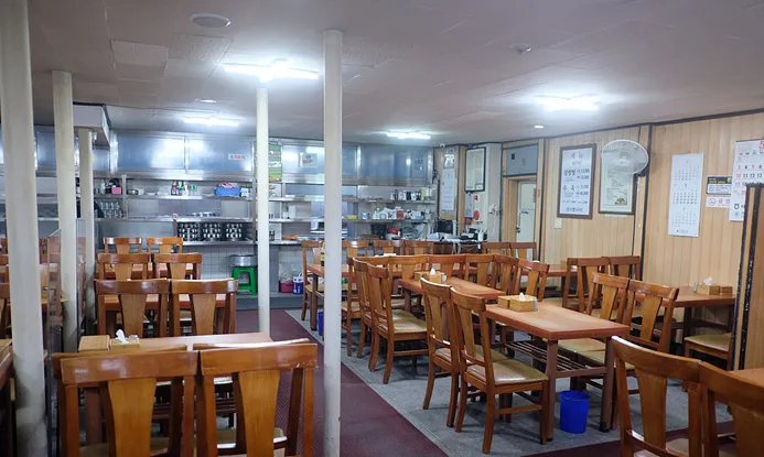 味成屋 — 木のテーブルと椅子が並ぶ店内