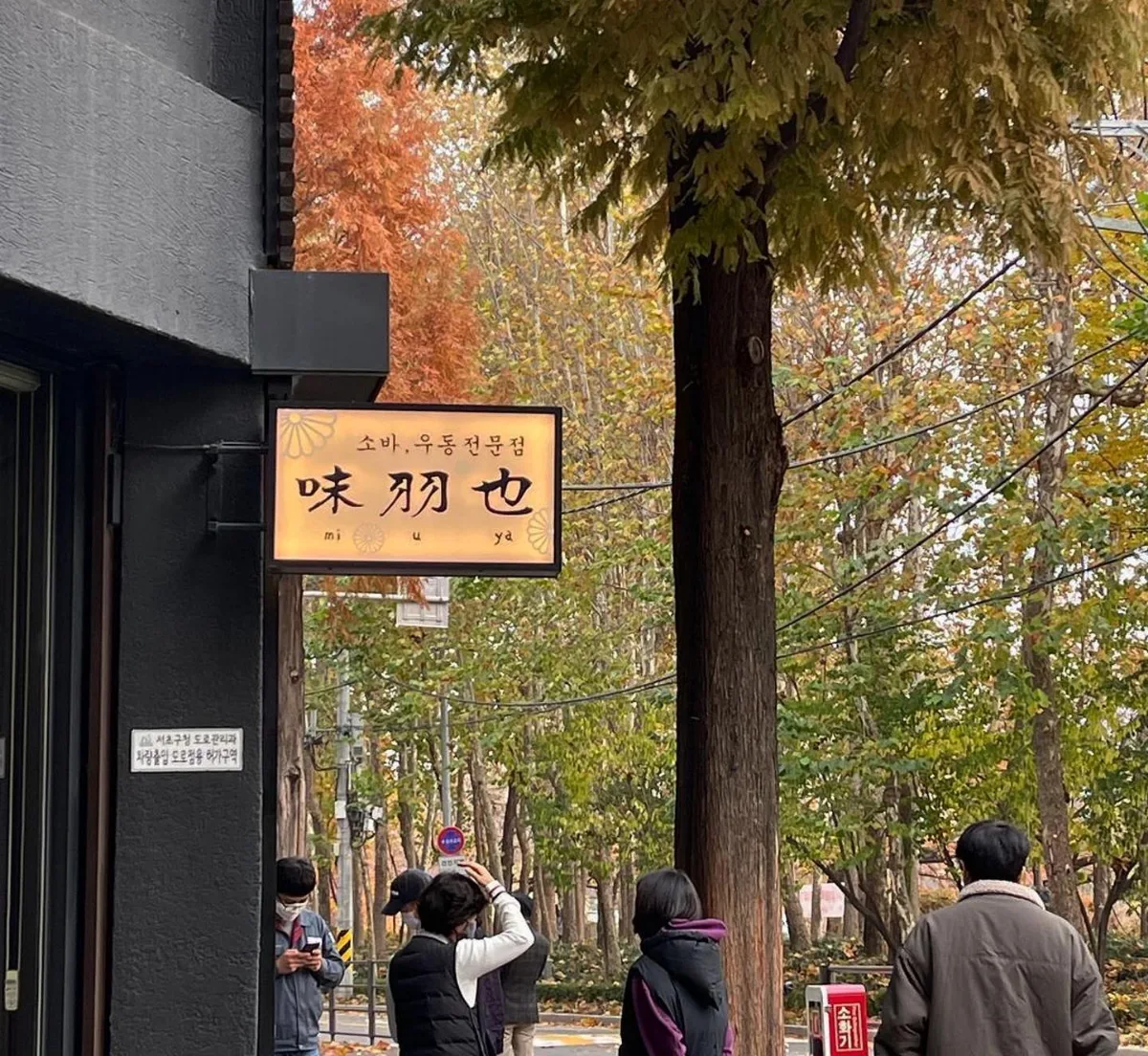 店の看板の下に集まる人たち