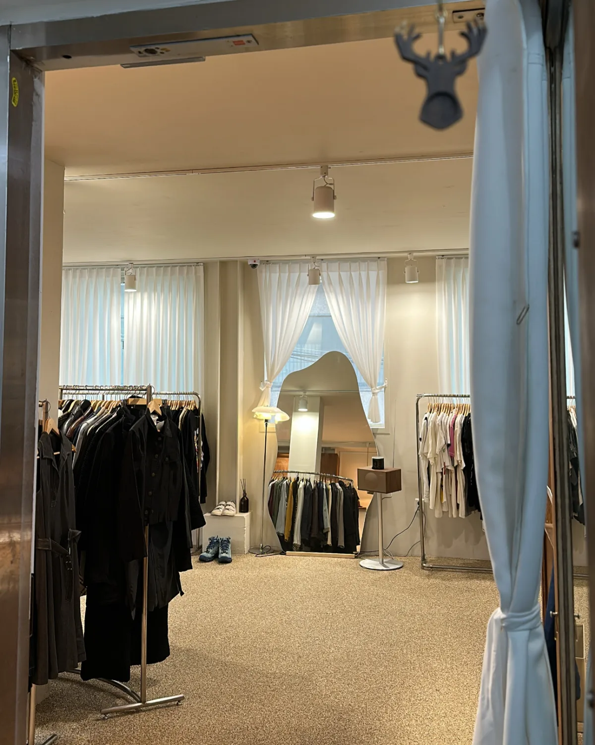 入口から見える服のラックと姿見